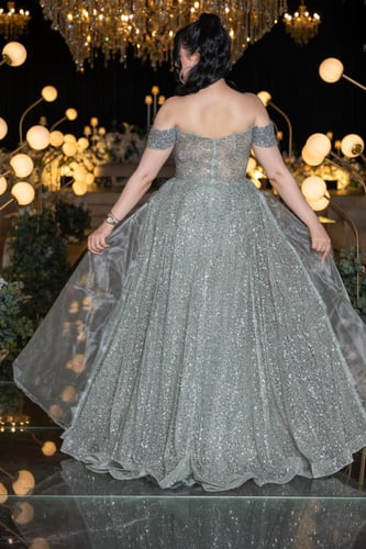 فستان سهرة فضي مطرز بترتر لامع وتنورة شفافة فاخرة