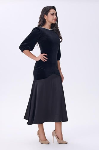 فستان أسود مخملي بتفاصيل لؤلؤية عند الياقة