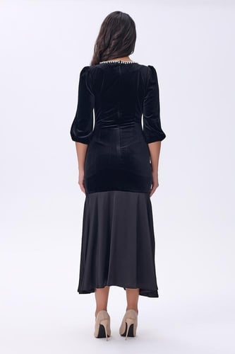 فستان أسود مخملي بتفاصيل لؤلؤية عند الياقة