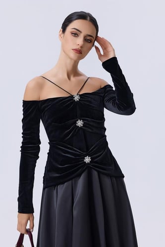 فستان أسود مخملي بأكتاف مكشوفة وتنورة واسعة