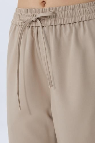بنطال واسع بخصر مطاطي ورباط بلون بيج