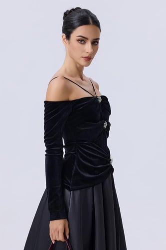 فستان أسود مخملي بأكتاف مكشوفة وتنورة واسعة