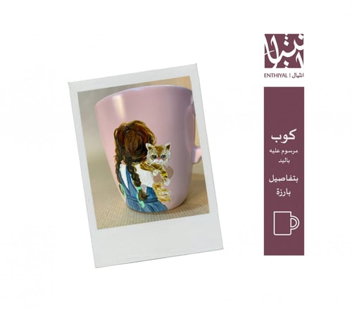 كوب رسم يدوي (مرسوم عليه طفلة ماسكة قطة)