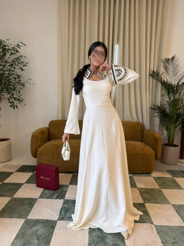 فستان أبيض بأكمام مطرّزة