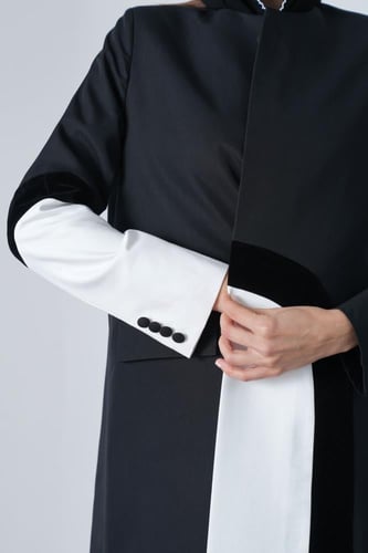 عباية بليزر أسود بوصلات طولية باللون الأبيض.