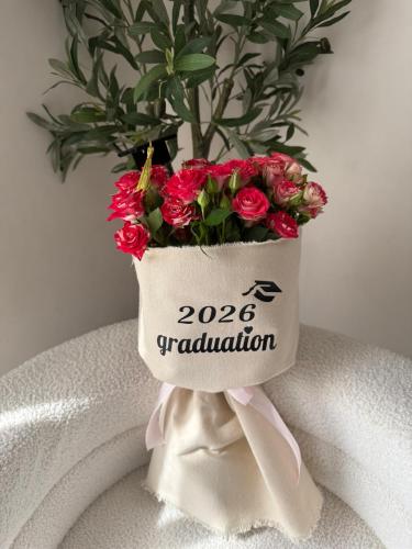 A bouquet of flowers with a graduation phrase