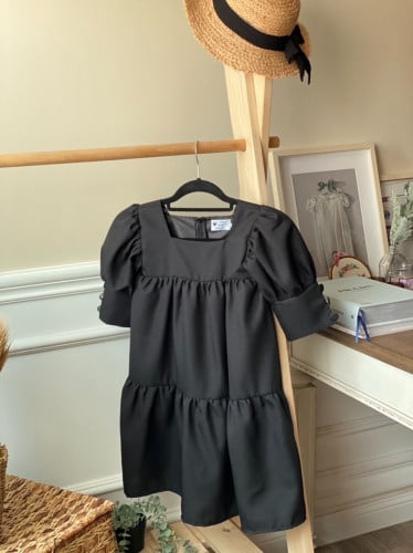 فستان أطفال باللون الأسود بقماش ناعم وكسرات في الص...