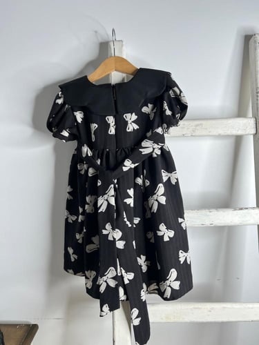 فستان أسود بطبعات فيونكات .