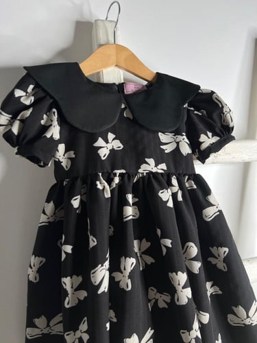 فستان أسود بطبعات فيونكات .