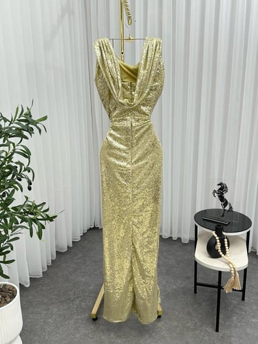 فستان ذهبي بترتر لامع وقصة ضيقة مع فتحة جانبية جذا...