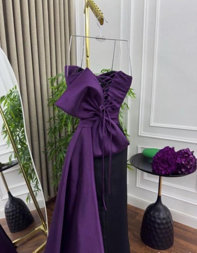 فستان سهرة بنفسجي بتصميم درامي وذيل أنيق