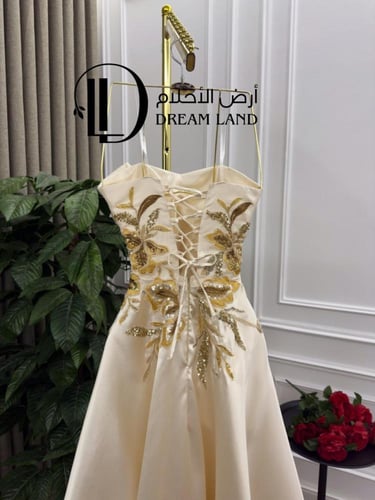 فستان سهرة كريمي بتطريز ذهبي وقصة كورسيه