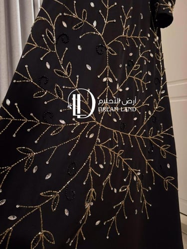 فستان سهرة أسود بتطريز ذهبي وأكمام كيب