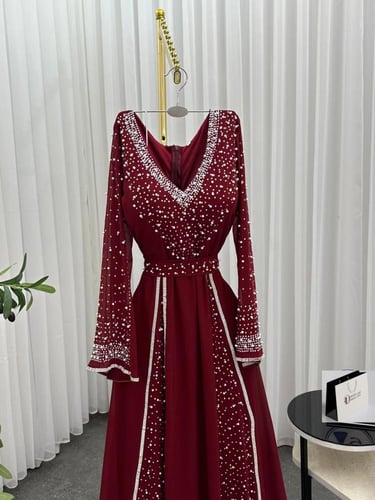 فستان سهرة عنابي بتطريز كريستالي وأكمام طويلة