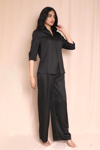 طقم نسائي أسود بقميص مخطط وبنطلون واسع