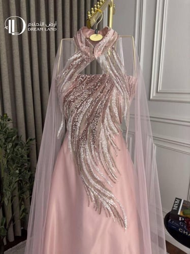فستان سهرة وردي بياقة منسدلة وتطريز فاخر
