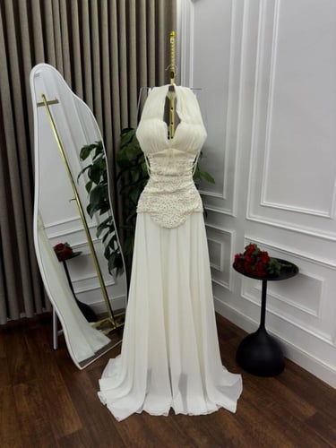 فستان سهرة أبيض بياقة هالتر وكورساج مطرز