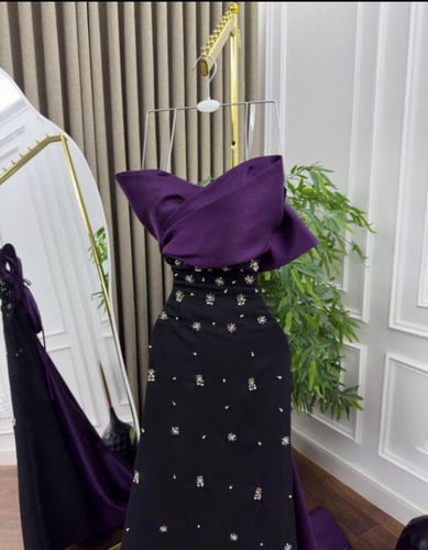 فستان سهرة بنفسجي بتصميم درامي وذيل أنيق