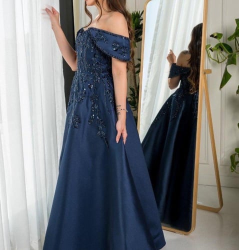 فستان سهرة كحلي بكتف منسدل وتنورة واسعة