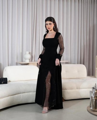 فستان سهرة أسود بأكمام شفافة وفتحة أمامية