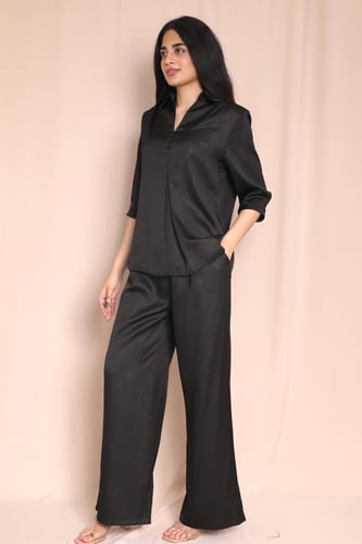 طقم نسائي أسود بقميص مخطط وبنطلون واسع