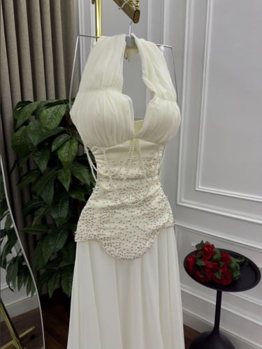 فستان سهرة أبيض بياقة هالتر وكورساج مطرز