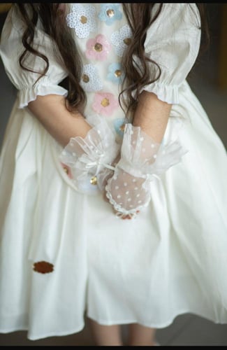 فستان ابيض مزين بترتر ملون بتدرجات الوردي والسماوي...