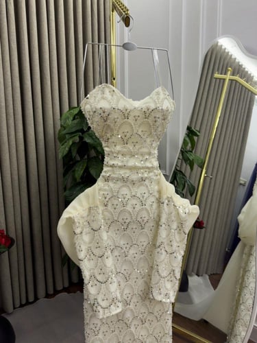 فستان سهرة طويل أبيض مطرز بترتر مع كشكش وذيل تول.