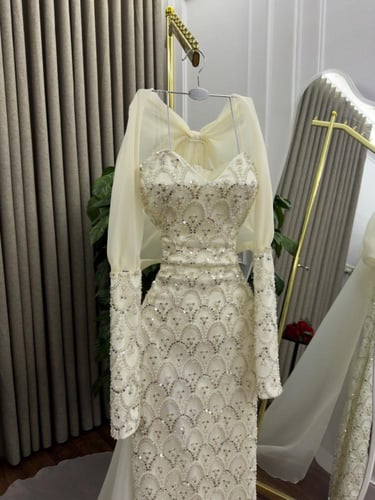 فستان سهرة طويل أبيض مطرز بترتر مع كشكش وذيل تول.