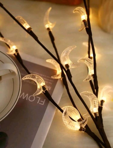 إضاءة فنية على شكل فروع شجر مصممة على شكل هلال