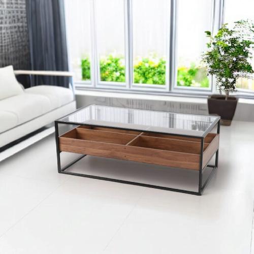 طاولة قهوة وسط بسطح زجاجي وقواعد معدن