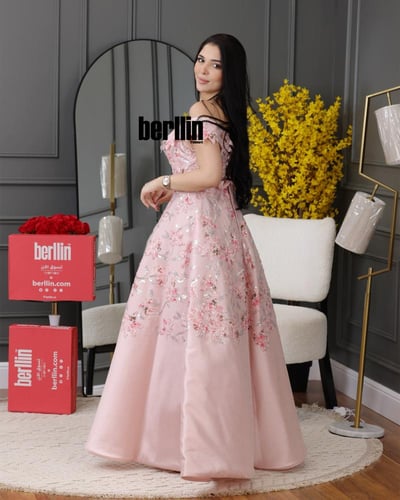 فستان سهرة وردي بأكتاف مكشوفة مزينة بورود مطرز