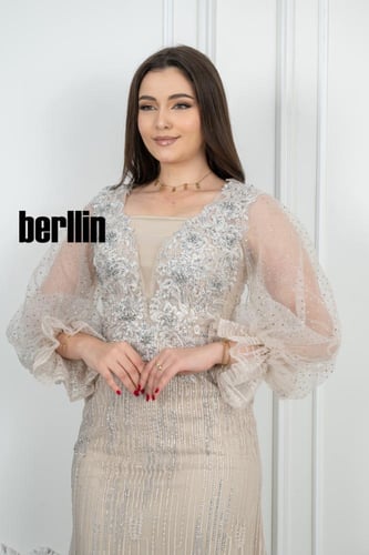 فستان سهرة أنيق بيج مزين بتطريز فضي فاخر وأكمام شف...