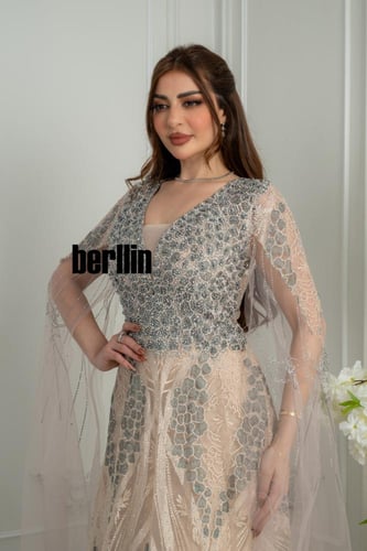 فستان سهرة طويل نيود بتطريز فضي كثيف وأكمام كيب طو...