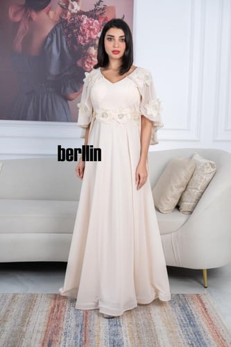 فستان أنيق بيج بتصميم طويل مزين بتطريزات على الأكم...