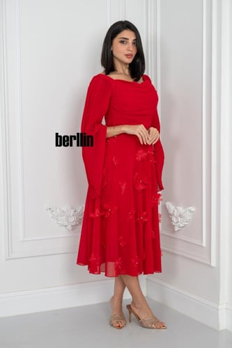 فستان أحمر أنثوي بتفاصيل ساحرة بتصميم درابيه