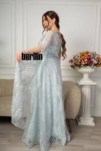 فستان سهرة مع تفاصيل كيب على الكتف وتطريز كامل لون...