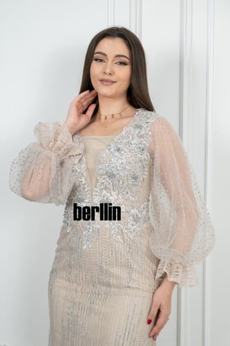 فستان سهرة أنيق بيج مزين بتطريز فضي فاخر وأكمام شف...