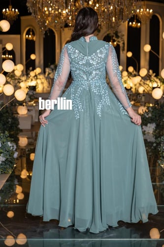 فستان سهرة طويل أخضر مطرز بالورود مع ياقة عالية وأ...