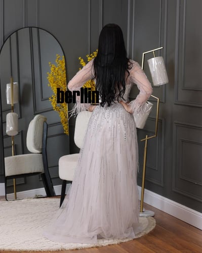 فستان سهره مزين بالريش والفصوص بأكمام مميزة بالريش...