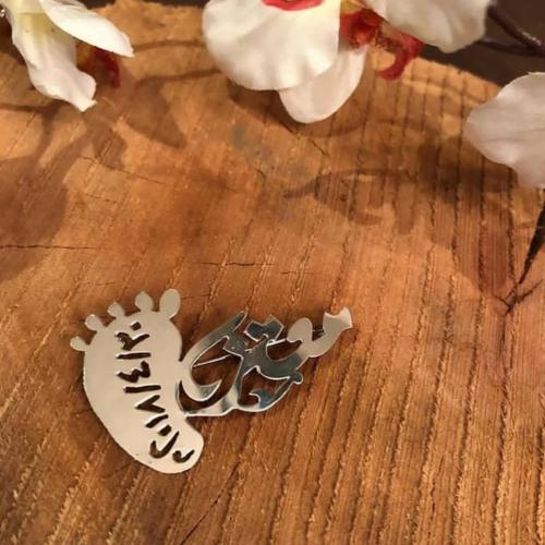 بروش اطفال بالاسم مع قدم طفل صغير محفور بها تاريخ