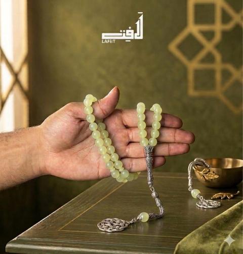 A light green prayer bead with a silver tassel