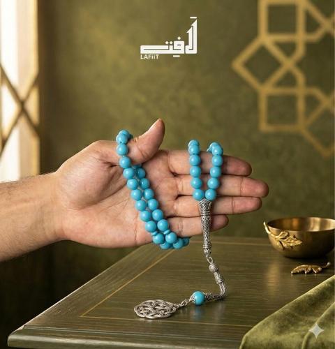 A turquoise rosary with a silver charm
