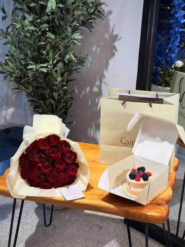 A bouquet of red flowers with a ganache cake