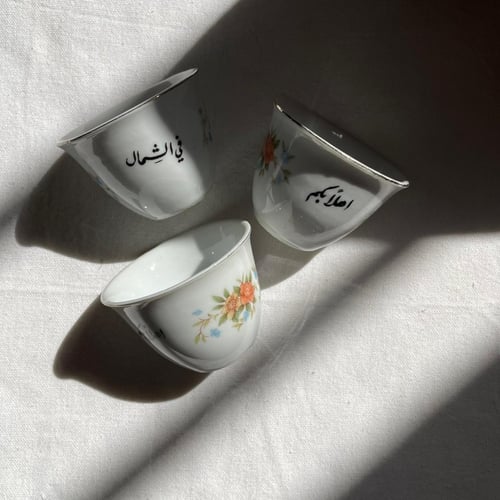 فنجان قهوة عربية قديم مكتوب عليه "اهلاً بكم في الش...