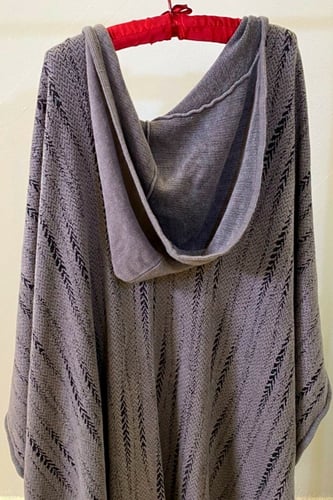 رداء بقبعة مع جيوب وبروش أنيق وعملي.