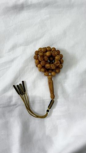 A tasbih with a color of caramel, with a decorativ...