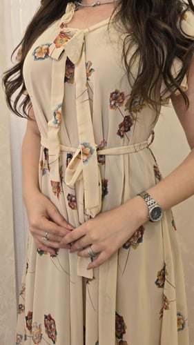 فستان بيج أنيق بنقوش زهرية وربطة عنق لمظهر أنثوي س...