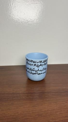 كوب فلات وايت أزرق رسمة وأبيات شعرية من الخلف _ لا...