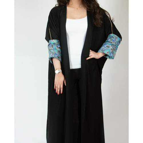 عباية سوداء بأكمام زرقاء مموجة